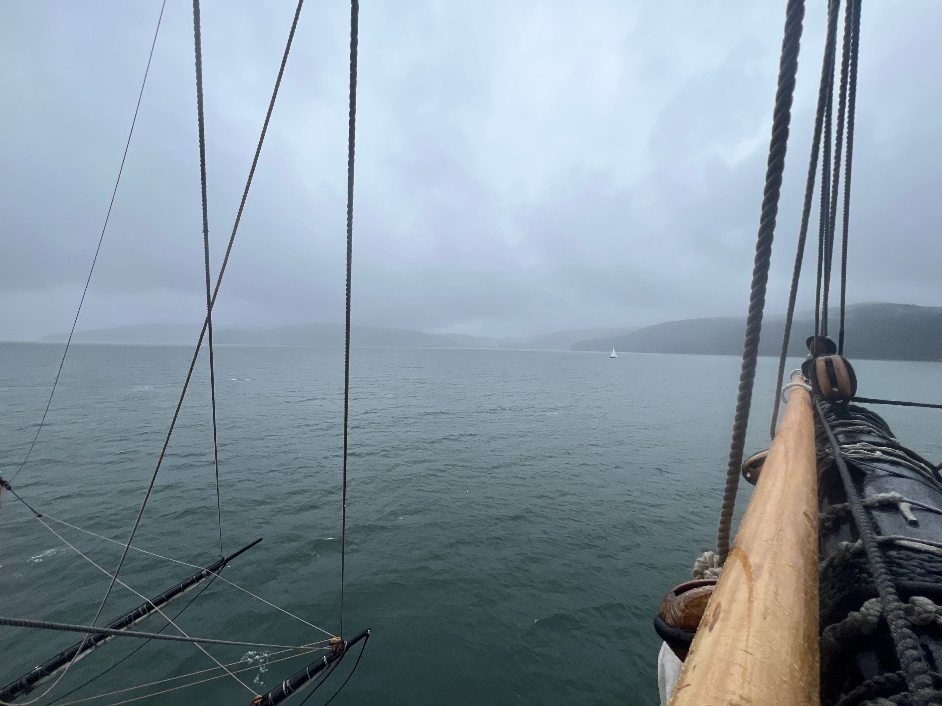 A Photo of the view off a ship with land on the horizon
