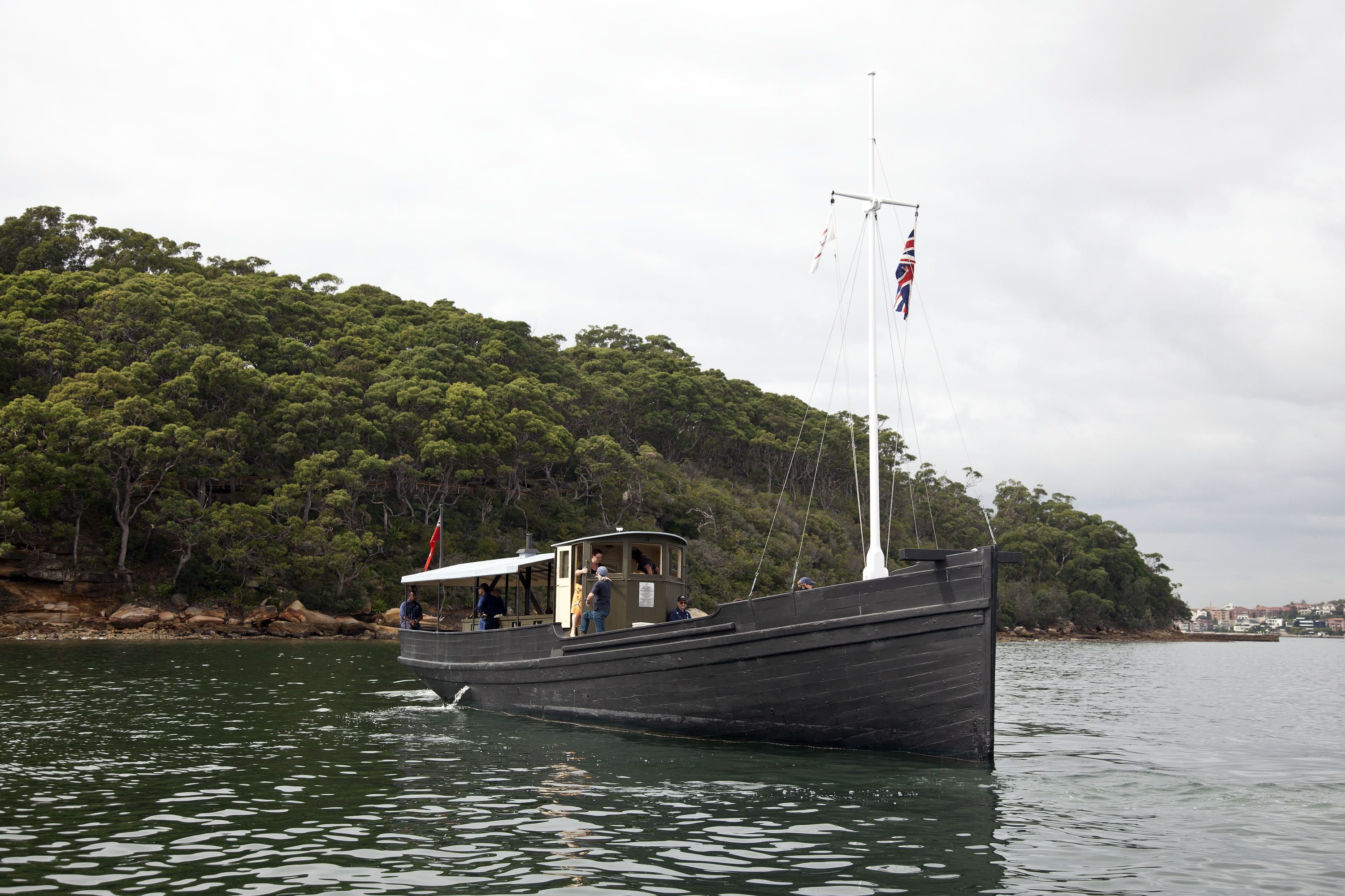Photo of a fishing boat, MV KRAIT on the Harbour with green foliage behind it. 