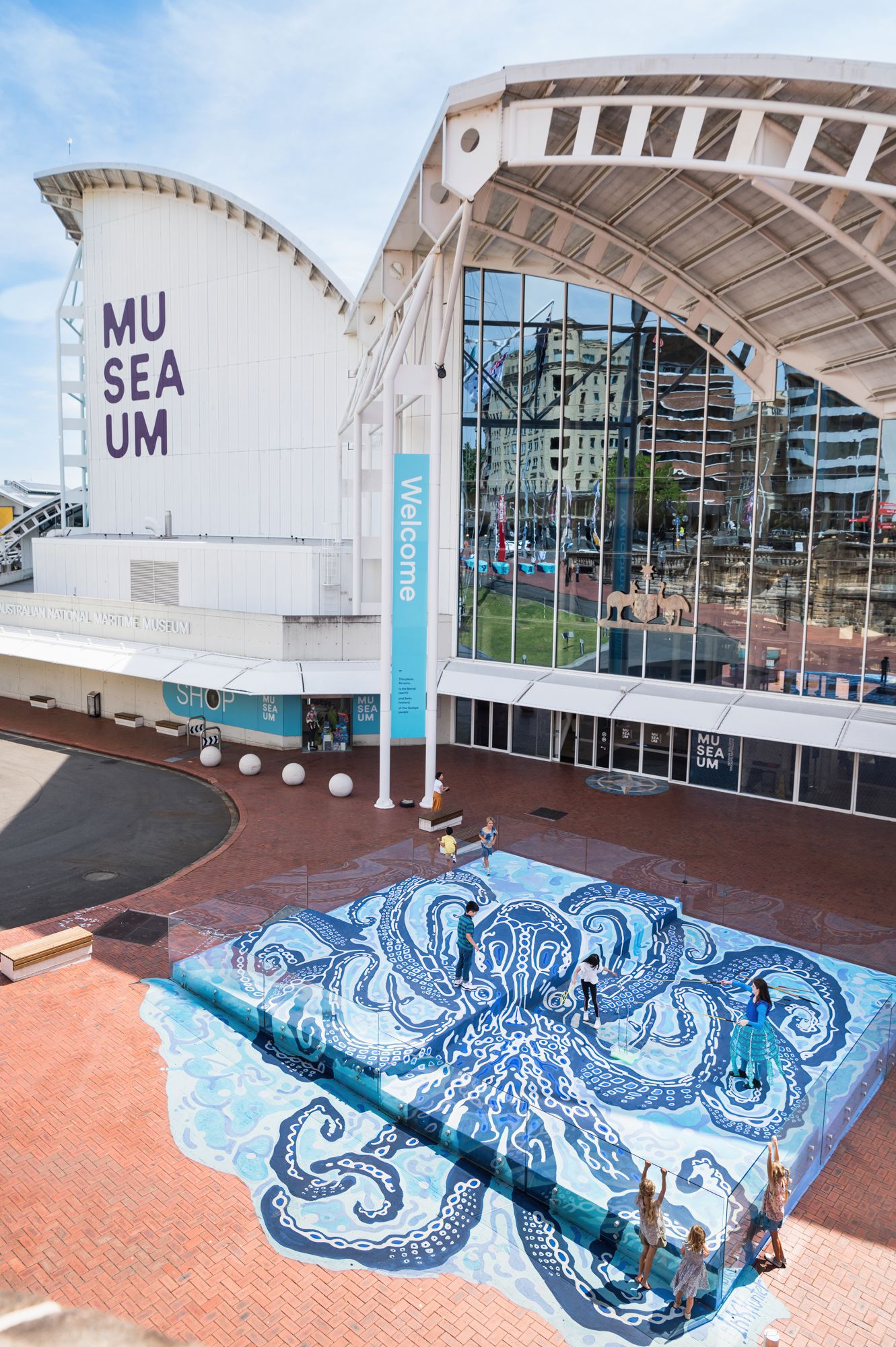Photo looking down on a large mural or a blue octopus.