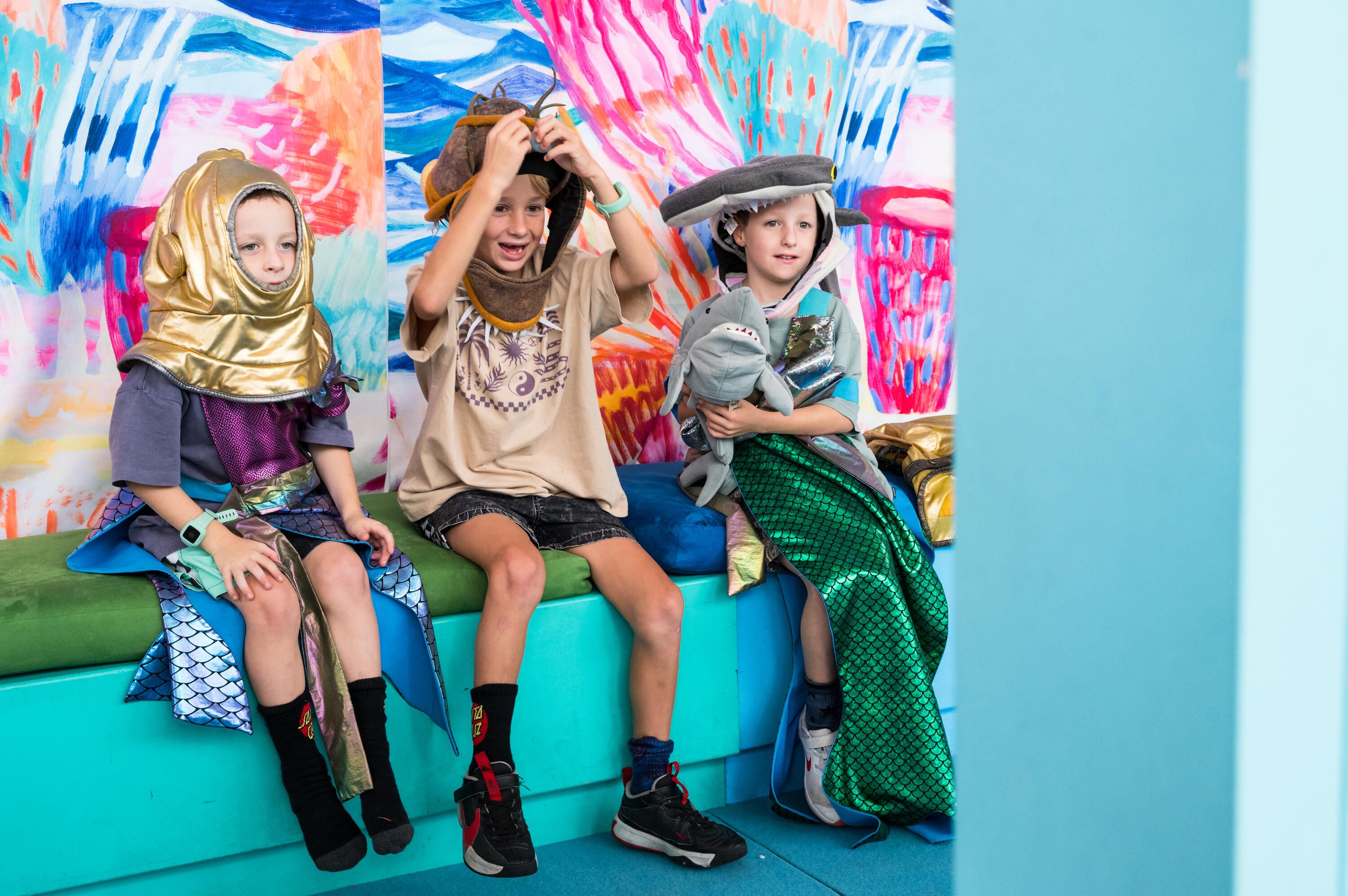 Photo of 3 children in underwater themed dress-ups posing for a photo booth