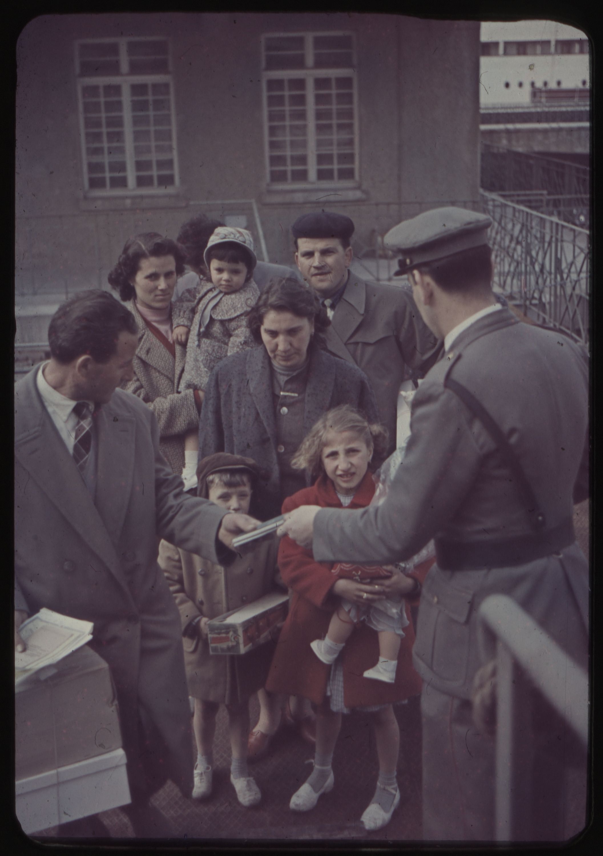 People having tickets checked by an official before embarkment