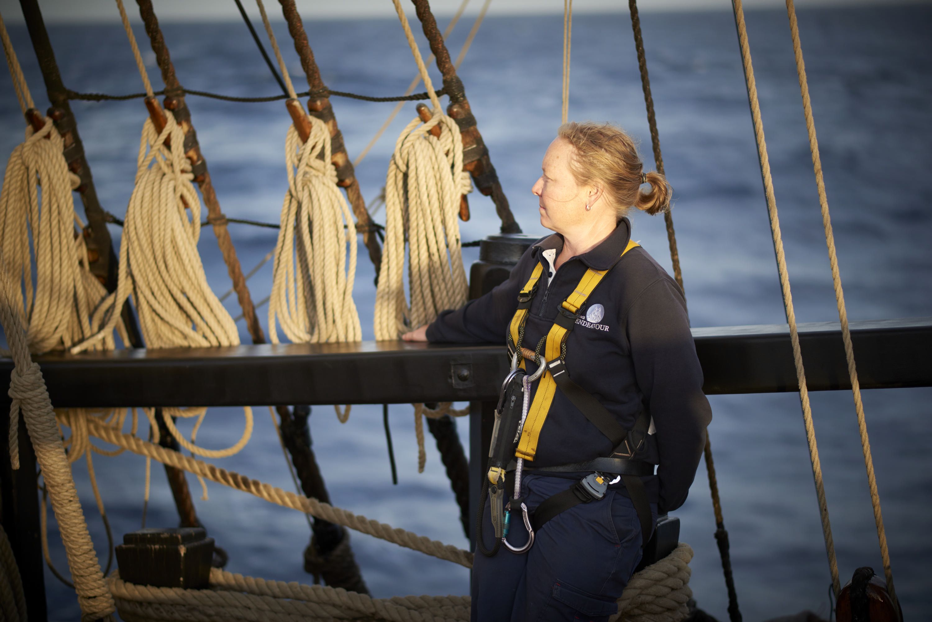 Female Shipkeeper onboard a tall ship, looking out to sea. 