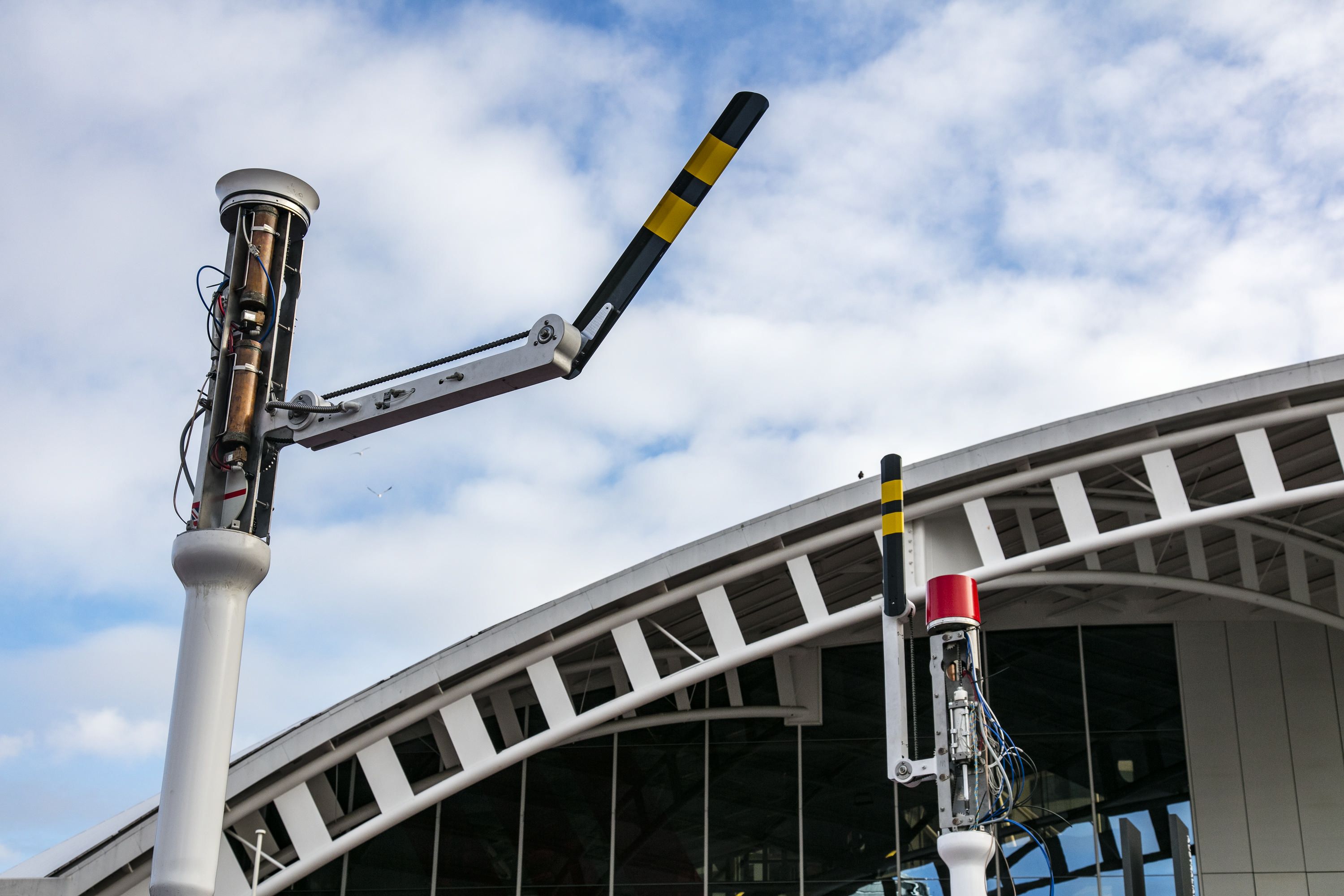 Photographs document the installation of the new public art sculpture showing wiring inside tall pillars. 