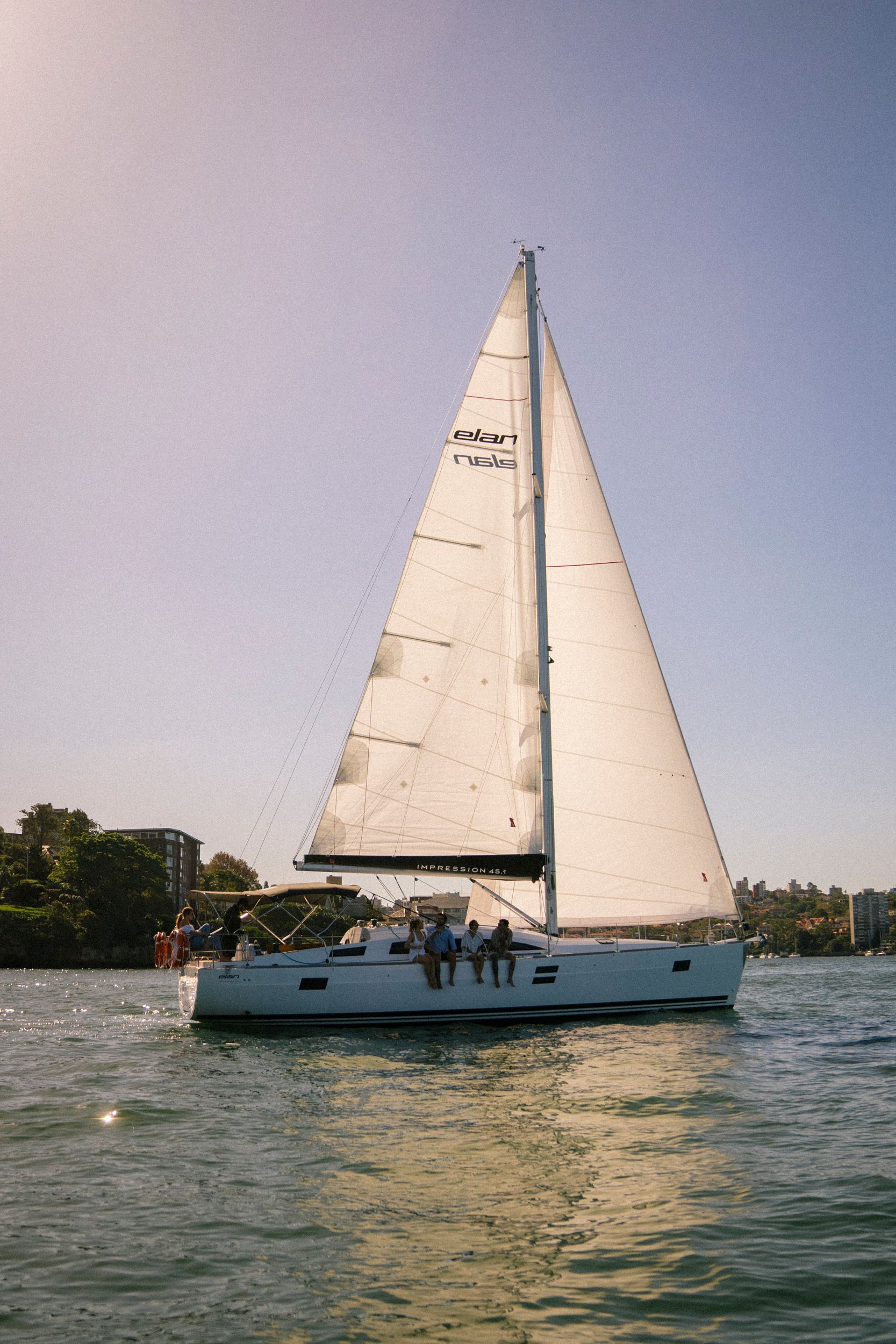 Photo of a sailing yacht, backlit on Sydney harbour. 