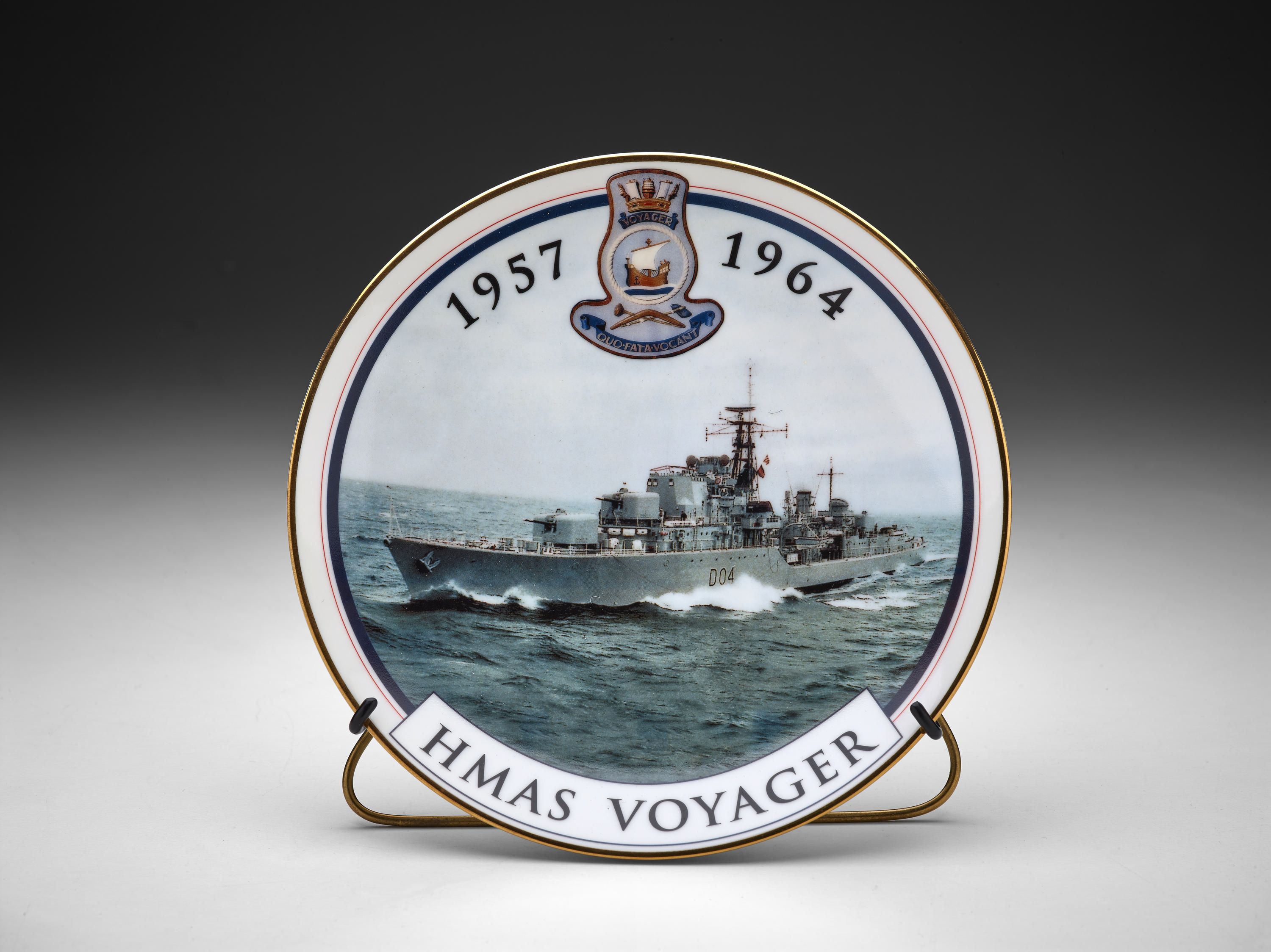 Gold rimmed plate with colour image of HMAS VOYAGER, Daring class destroyer at sea. Printed at the top is "1957 [VOYAGER Logo] 1999". Printed at the bottom is: "HMAS VOYAGER". Printed on the back of the plate is: "In commemoration / of the 35th anniversary / of the loss of / HMAS VOYAGER / 1964 - 1999 / plate no: 350 / designed and decorated in Australia - blank made in Japan".