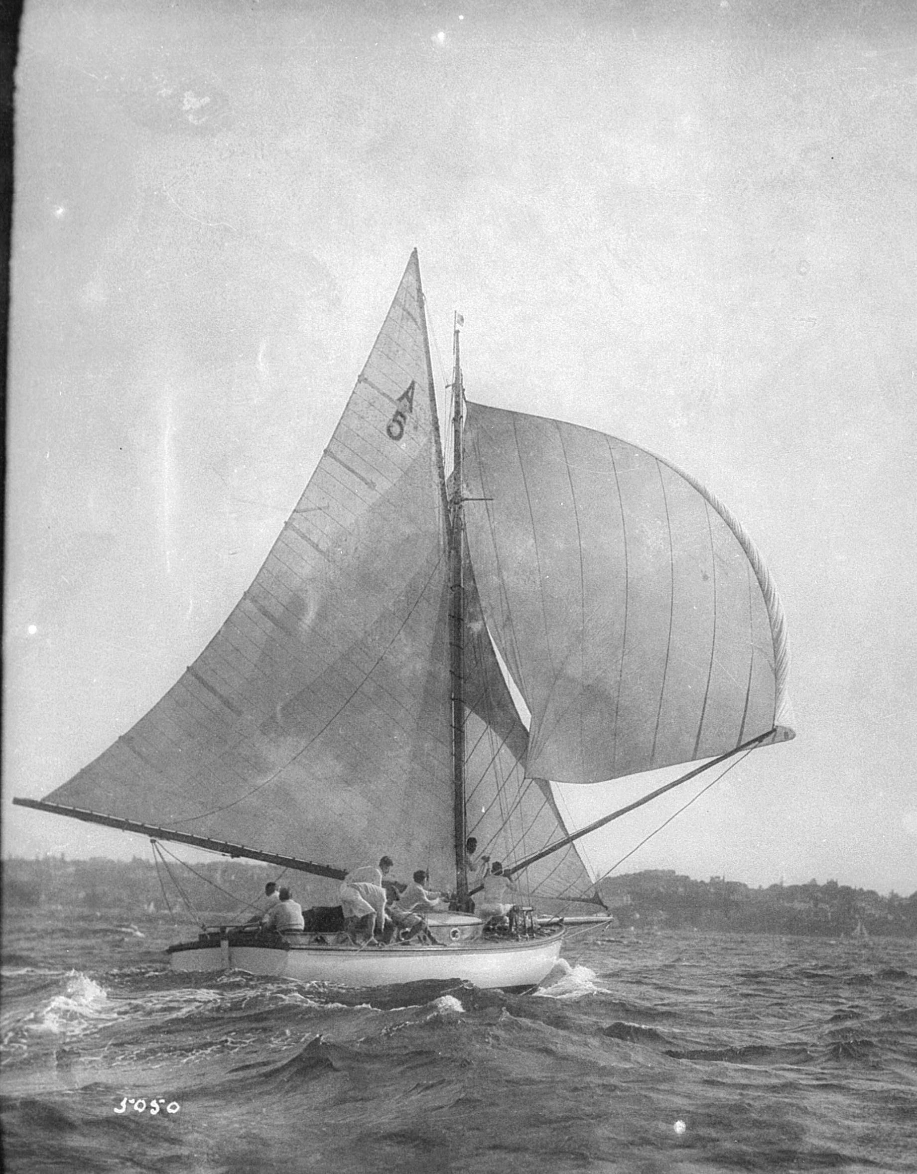 Black and White Photograph of a small sailing boat with white sails.