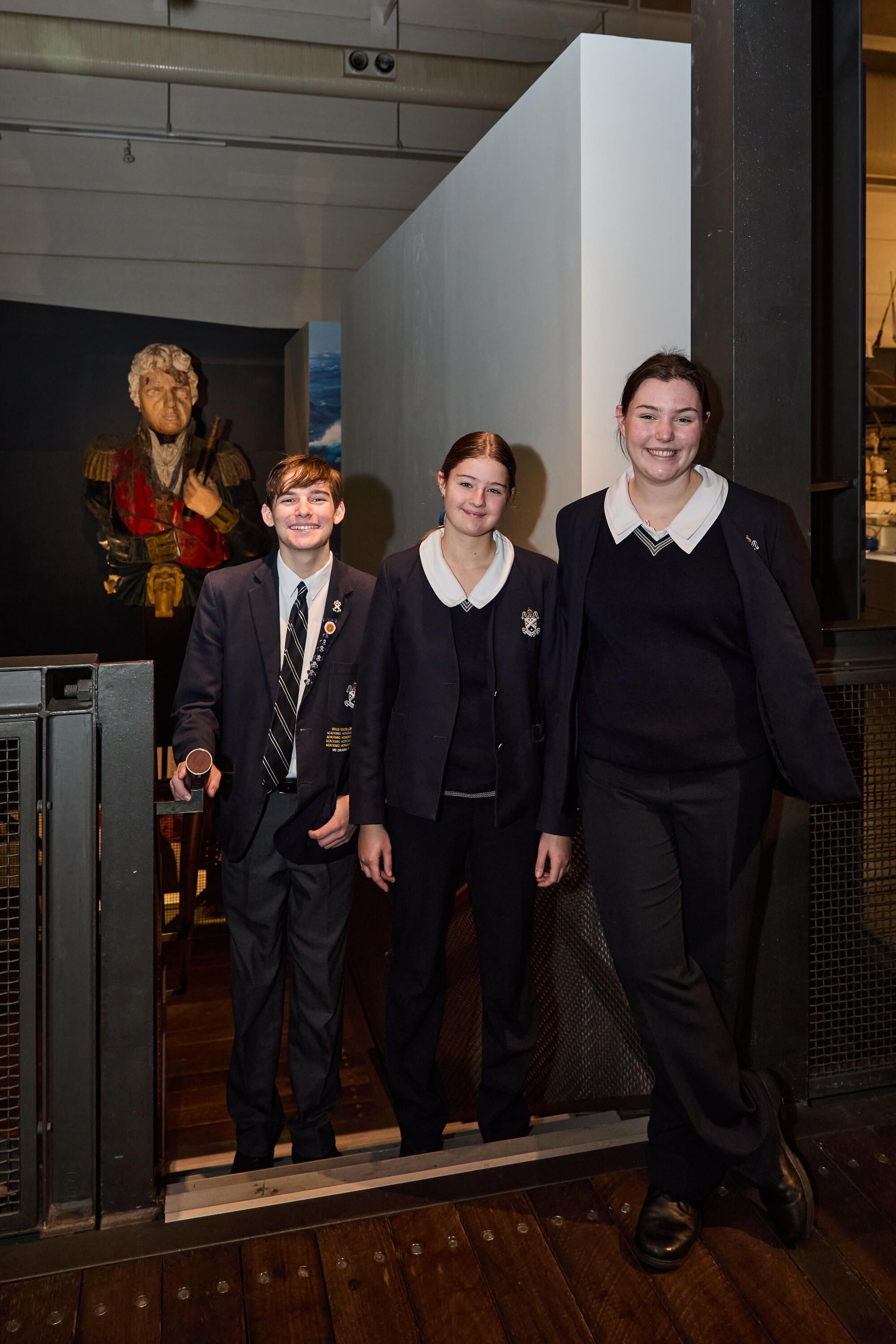 Photo showing 3 high school students standing in a museum exhibition