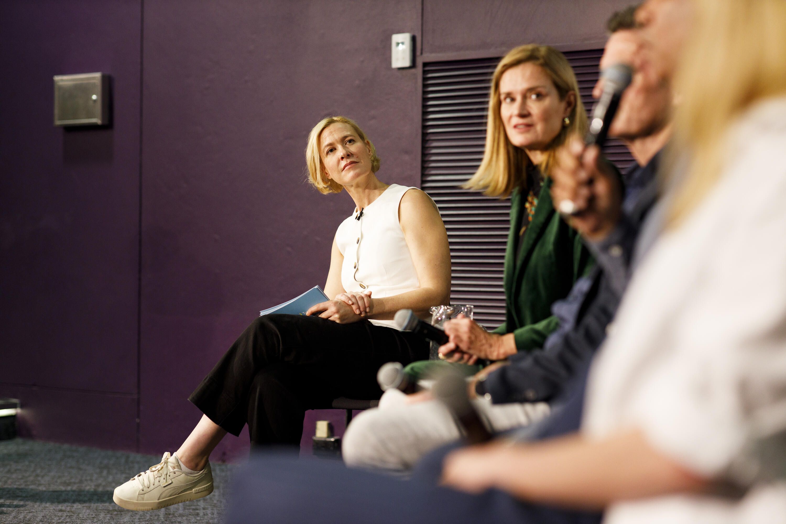 Photo looking down a line of people at the front of a theatre.