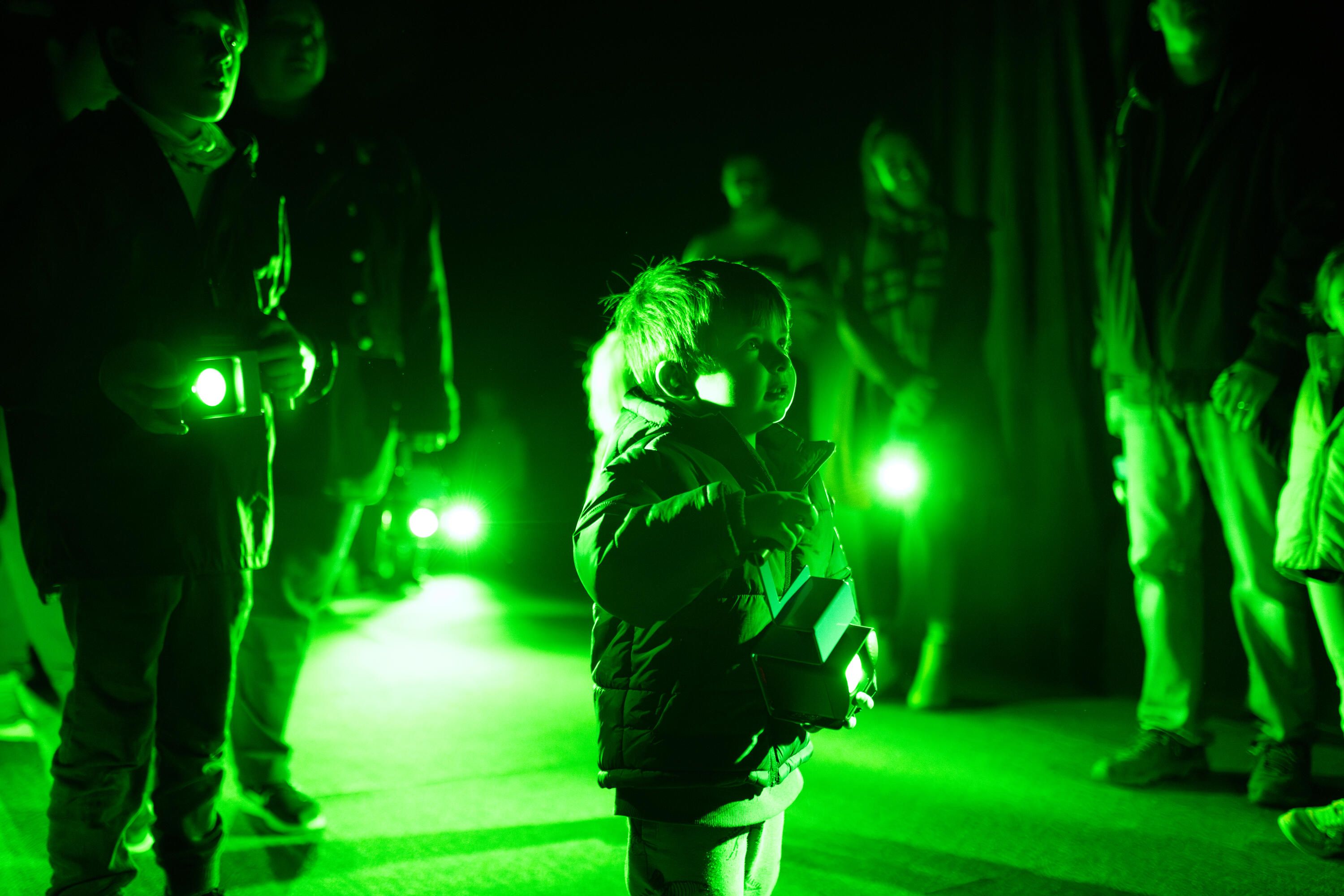 a child in a green lit space