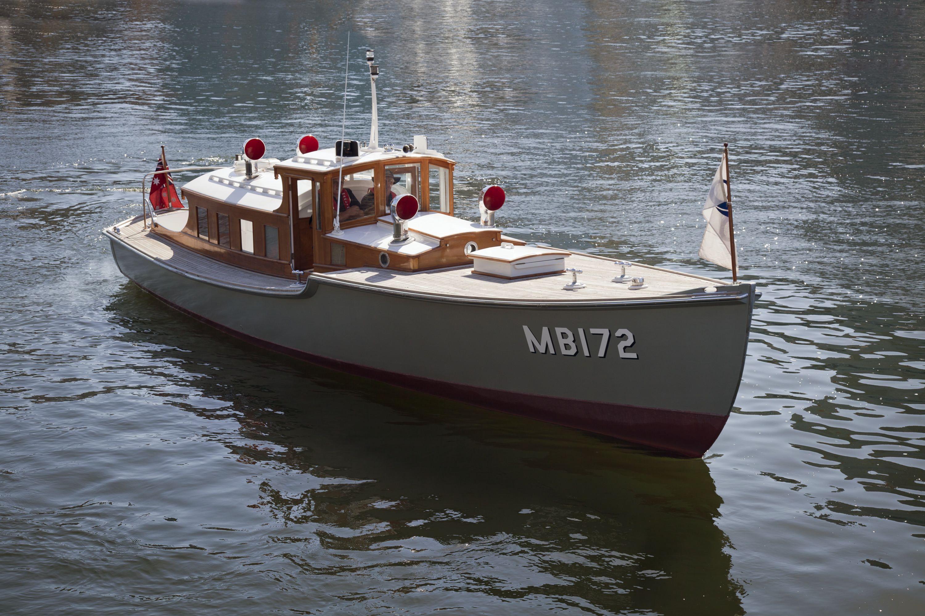 Small wooden boat with a grey hull and MB172 painted on the front. 