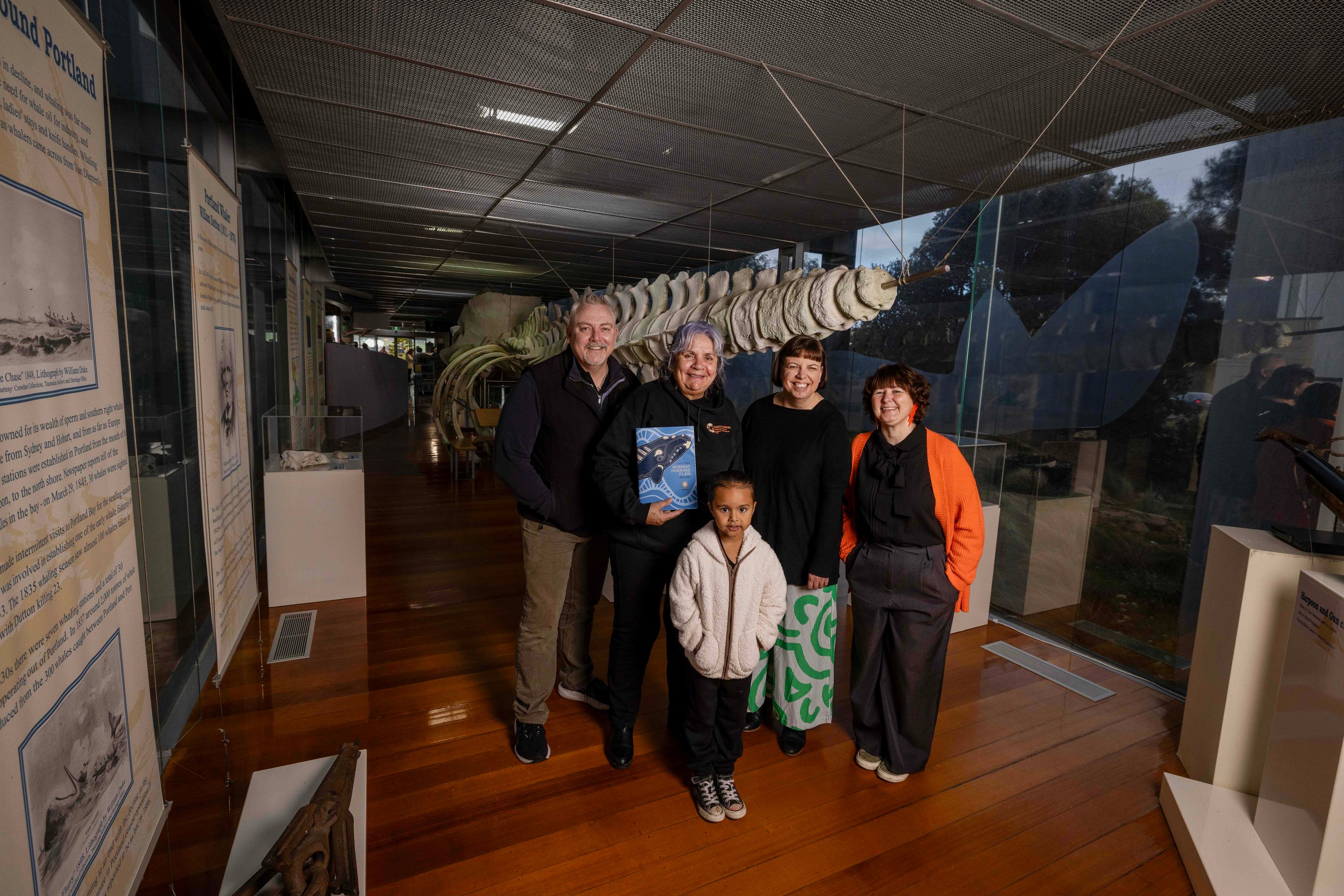 A group of people standing in a museum gallery.