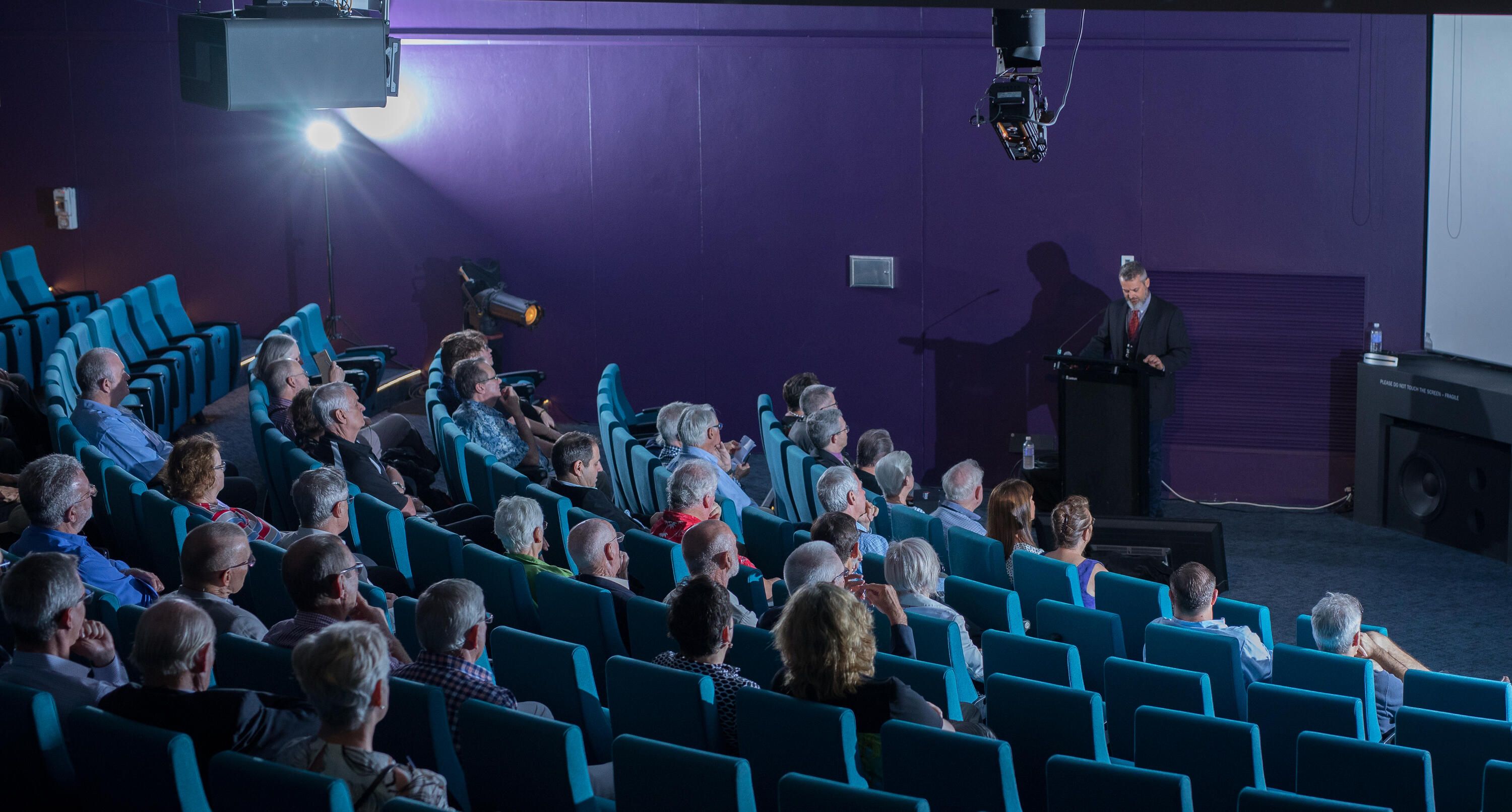 photo of a large audience in the museum theatre