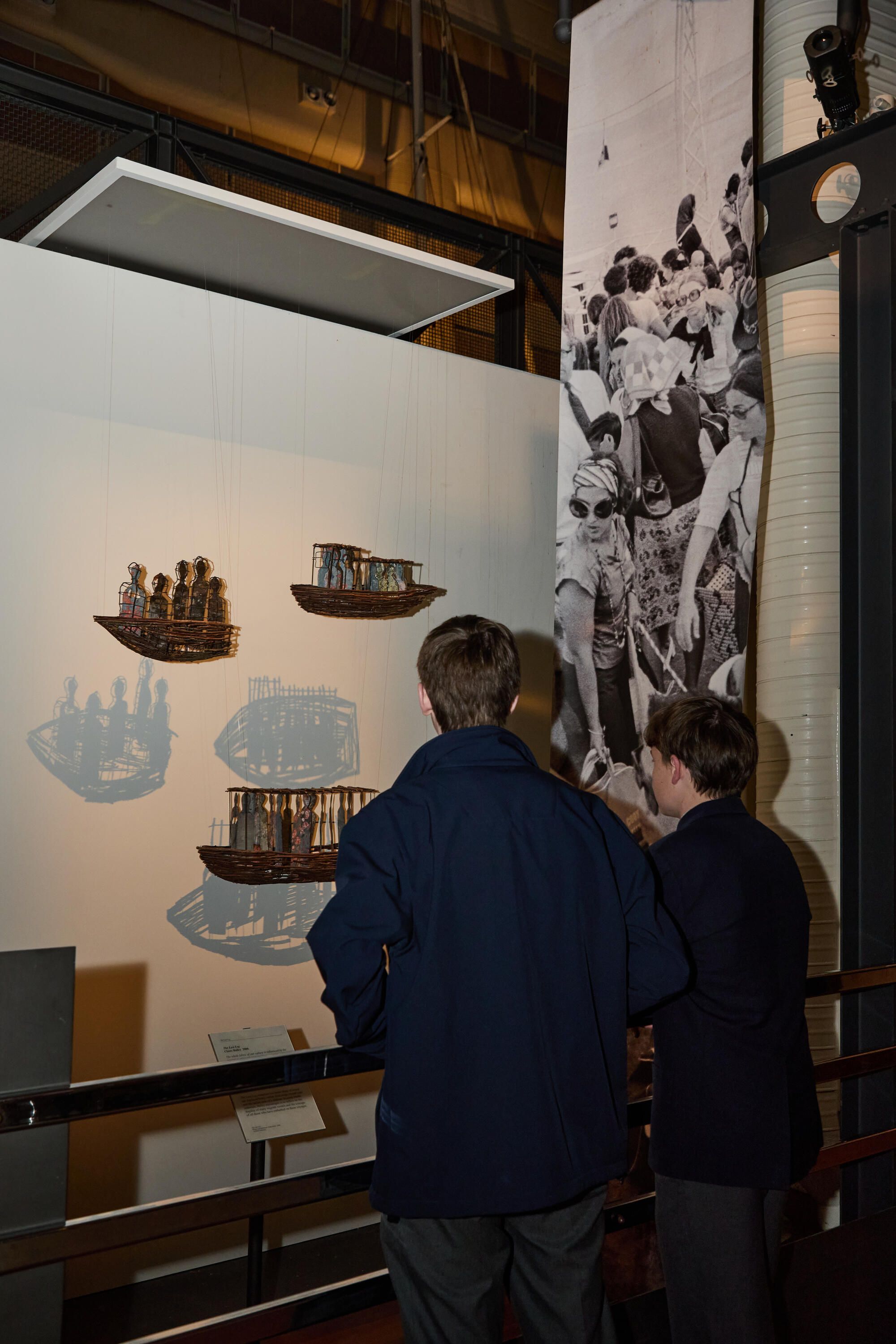 Photo of students in a museum gallery looking at a metal sculpture.