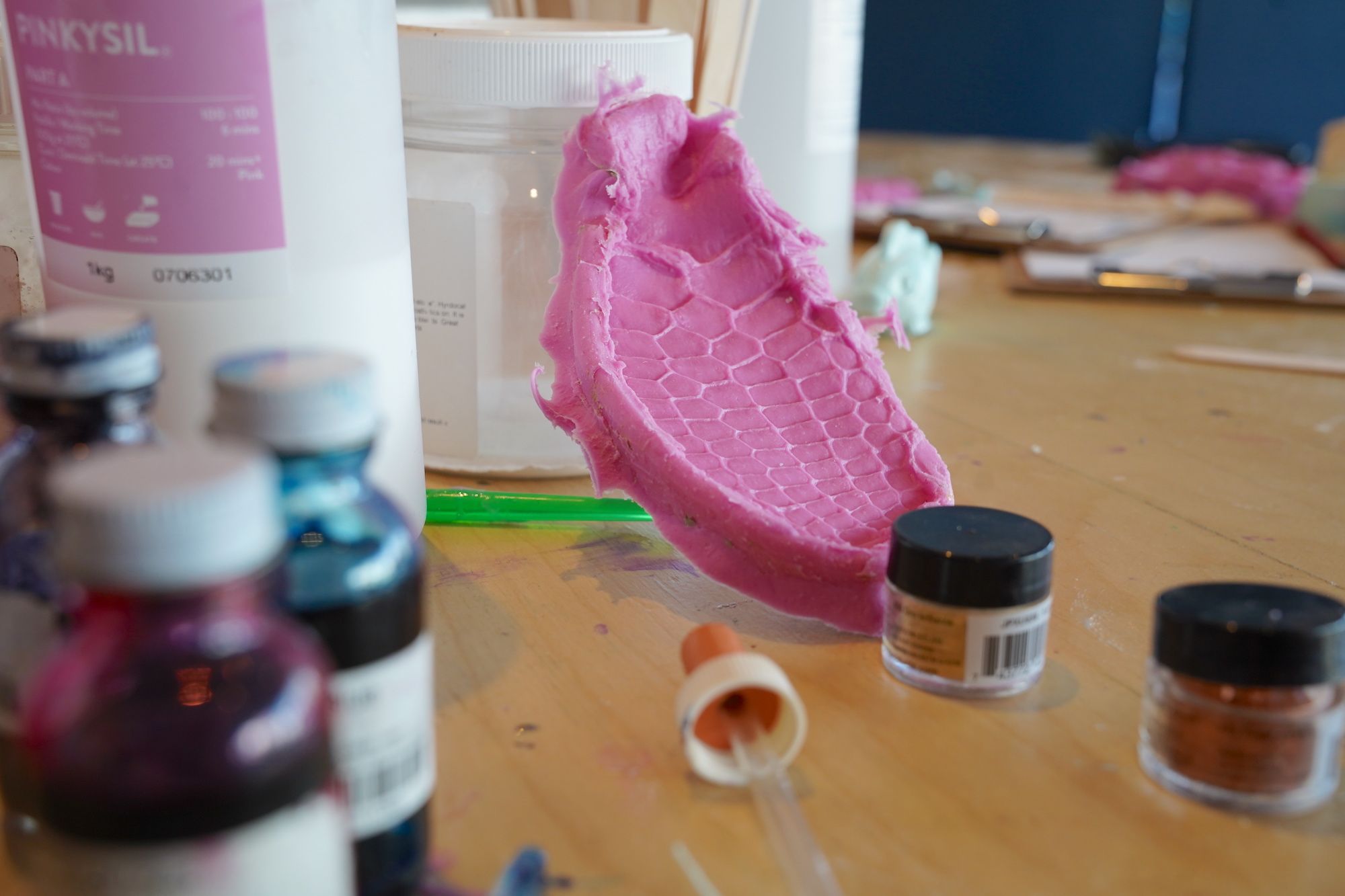 A table with a pink silicone mould and other craft materials