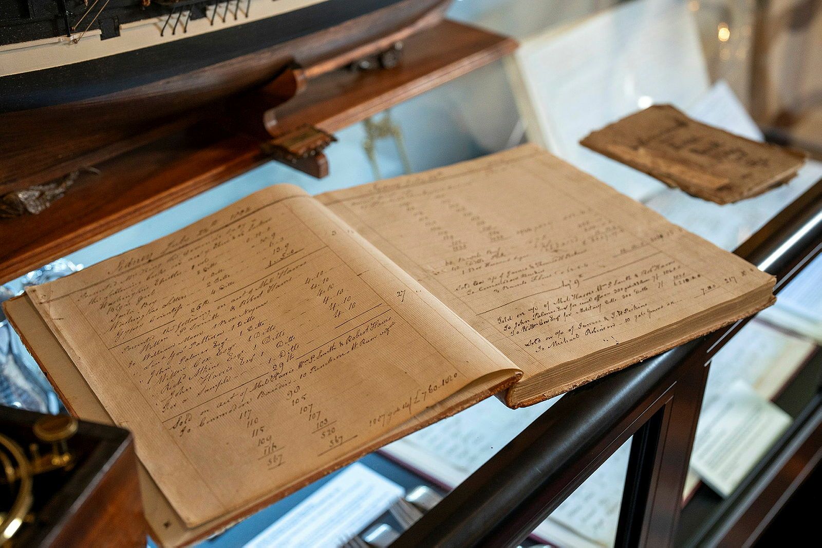 Photo of a booklet with yellowed pages and lines of handwritten, cursive text.