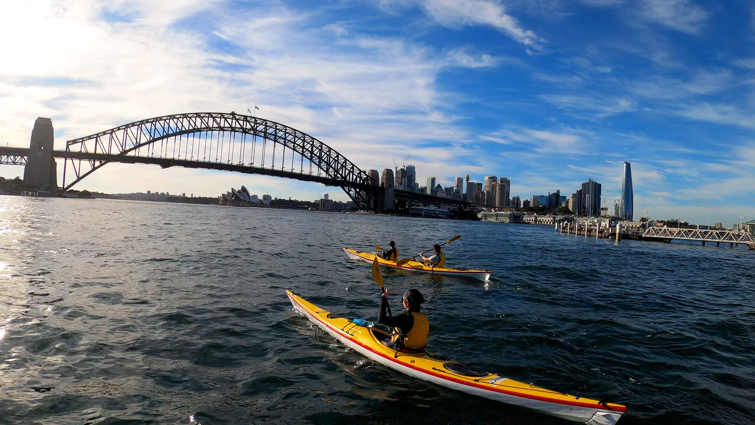 Photo showing 2 double kayaks in the water looking towards the Sydney harbour bridge.