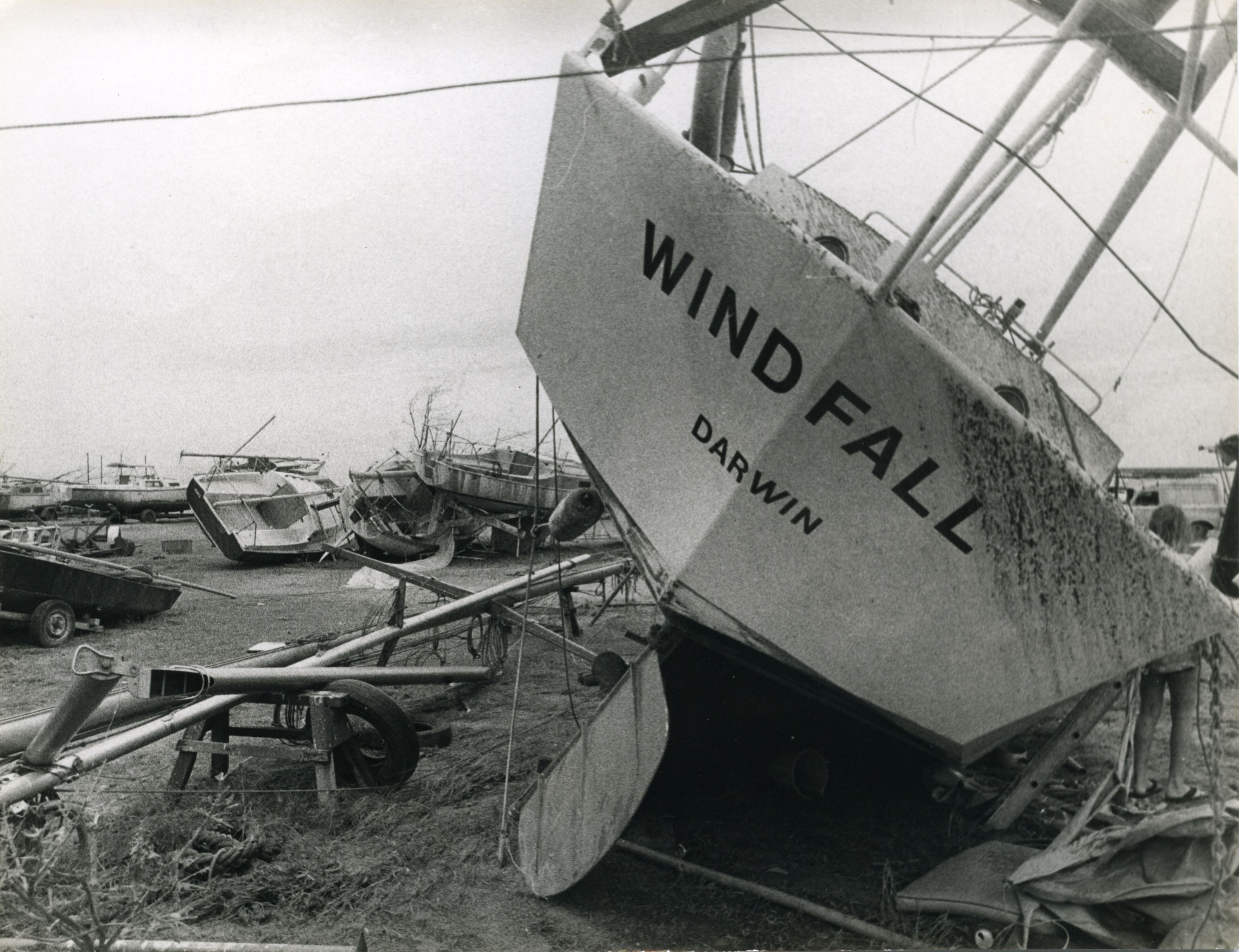 Black and white photograph showing damaged sailing boats at the Darwin Sailing club